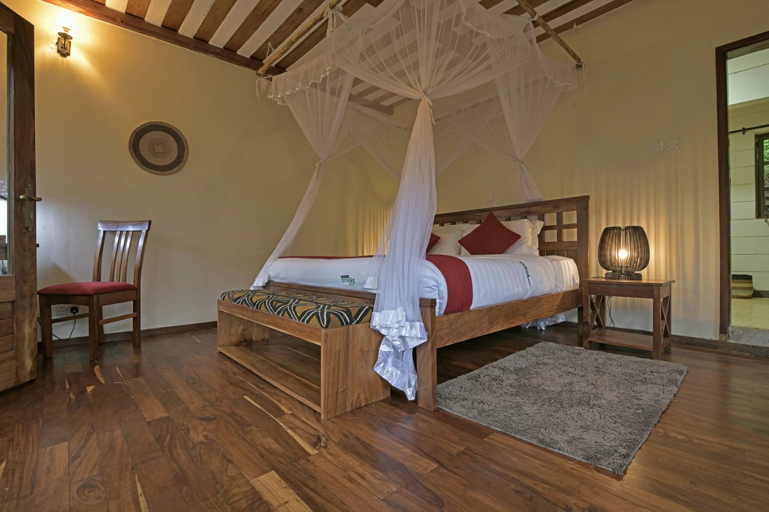 Cottage bedroom with forest-view windows at Four Gorillas Lodge, Rushaga